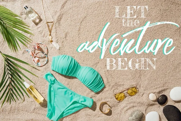 mavi bikini çeşitli aksesuar ve çakıl taşları ile üstten görünüm 