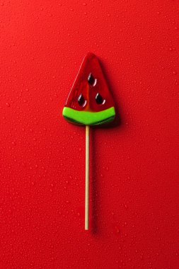 lolipop karpuz şeklinde üstten görünüm kırmızı yüzeyi su ile damla