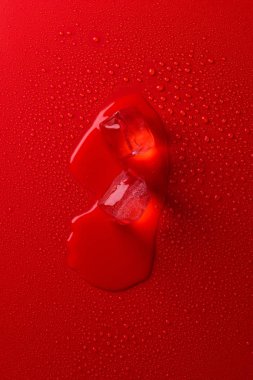 su damlaları ile kırmızı yüzeyinde buz erime üstten görünüm