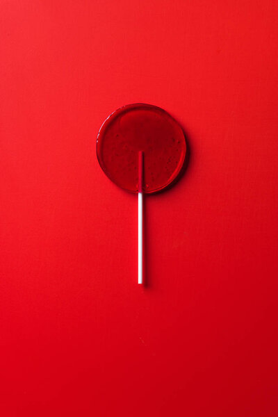 top view of one lollipop on red surface