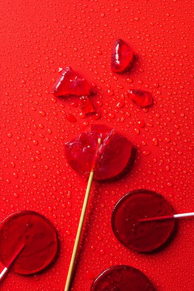 Bovenaanzicht Van Lollies Rode Ondergrond Met Water Druppels — Stockfoto