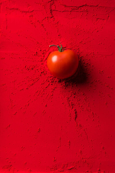 top view of red tomato on red powder