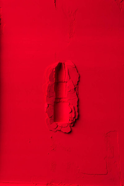 вид сверху на форму помады на красном порошке
