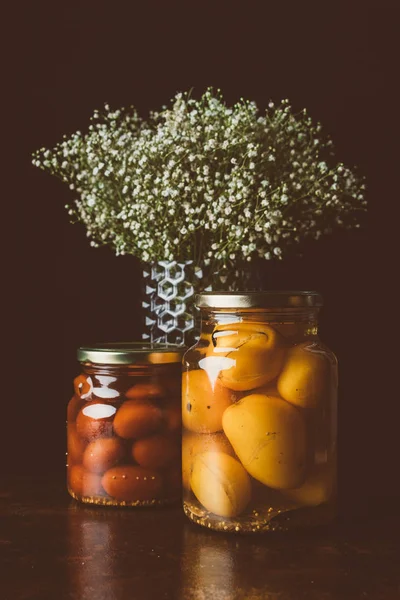 Jarros Vidro Com Tomates Preservados Flores Mesa Madeira Cozinha Escura — Fotografia de Stock