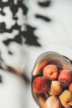 düz lay ile gölgeler ile hafif mermer yüzeyindeki metal kapta olgun şeftali