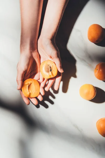 Partial View Woman Holding Pieces Ripe Apricots Hands Light Marble — Stock Photo, Image