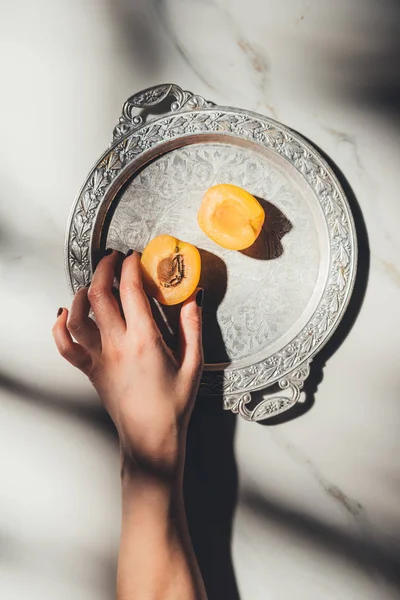 Cropped Shot Woman Holding Apricot Piece Metal Tray Light Marble — Free Stock Photo