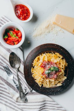 «Ana sayfa» görünümü tabak makarna ile parmesan, kase sos ve mermer masada kiraz domates rendesi 