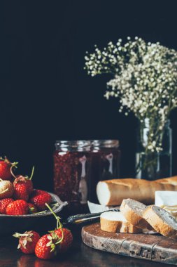 yakın bakış çilek, baget, reçel kavanoz ve siyah çiçekler 