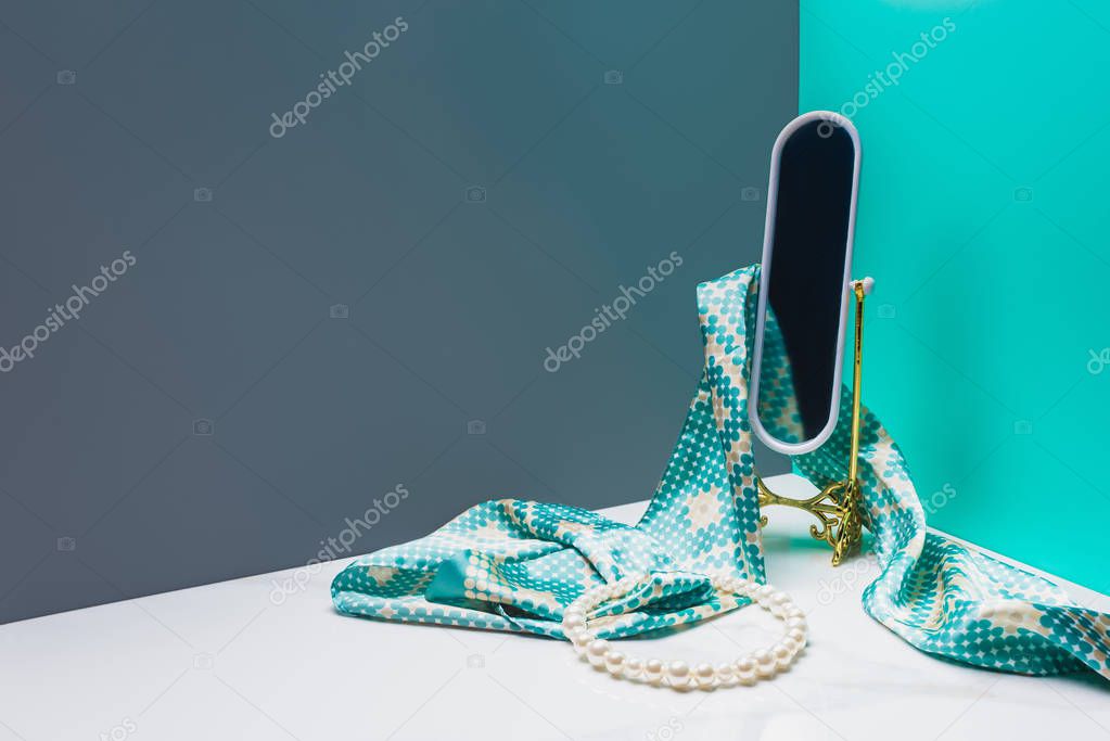 toy mirror with silk scarf and pearl necklace in miniature blue room