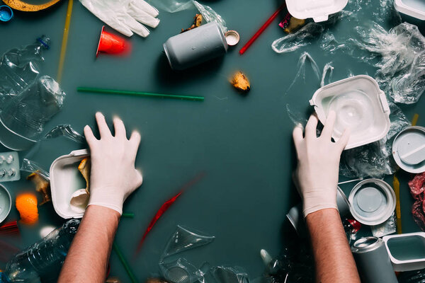 частичный взгляд человека в латексных перчатках, очищающих воду от мусора, концепция защиты окружающей среды
