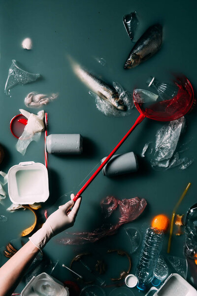 cropped shot of person in latex glove with butterfly net cleaning water from rubbish