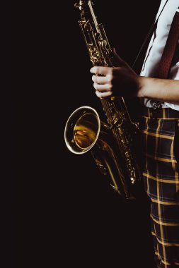 cropped shot of stylish young musician holding saxophone isolated on black clipart