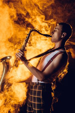 şık profesyonel saksofoncu sax duman oynamaya yan görünüm 