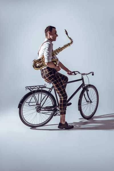 Jovem Músico Elegante Óculos Sol Segurando Saxofone Andar Bicicleta Cinza — Fotografia de Stock