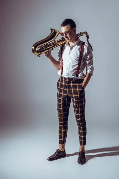 Joven Músico Con Estilo Gafas Sol Sosteniendo Saxofón Mirando Hacia — Foto de Stock