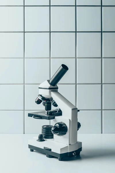 Microscópio Óptico Comprimido Branco Frente Parede Azulejos — Fotografia de Stock