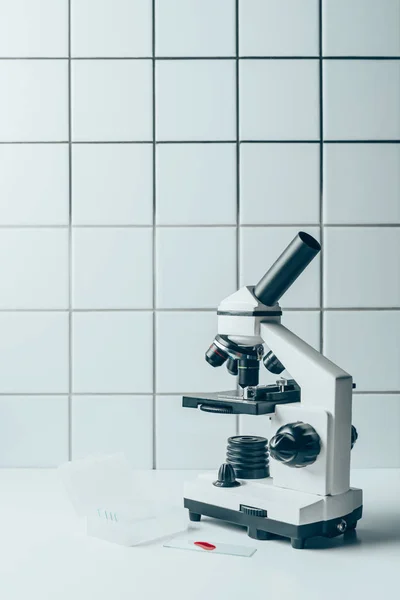 Próbki Krwi Mikroskop Optyczny Białej Tabletki Przed Wykafelkowanych Ścian — Darmowe zdjęcie stockowe