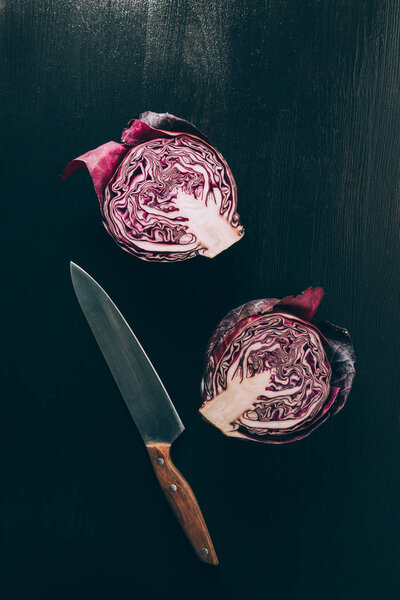 top view of cut red cabbage and knife on grey dark table