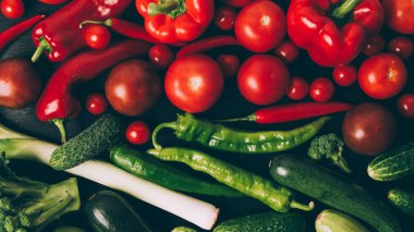 tablo üzerinde domates, biber, pul biber ve salatalık üstten görünüm