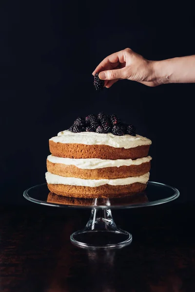 Tiro Recortado Mujer Decorando Sabroso Pastel Mora Soporte Vidrio Negro — Foto de Stock