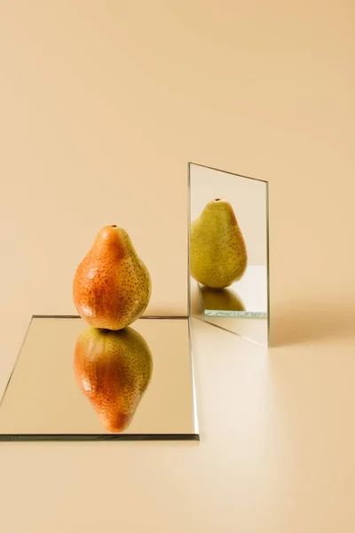 One Ripe Pear Reflecting Two Mirrors Beige Table — Stock Photo, Image