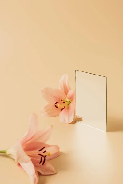 Lilienblüten Und Spiegel Auf Beiger Tischplatte — Stockfoto