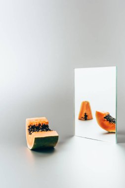 Aynada beyaz masaya yansıtan Papaya 
