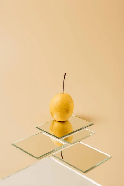 Poire Jaune Réfléchissant Dans Les Miroirs Sur Surface Beige — Photo gratuite