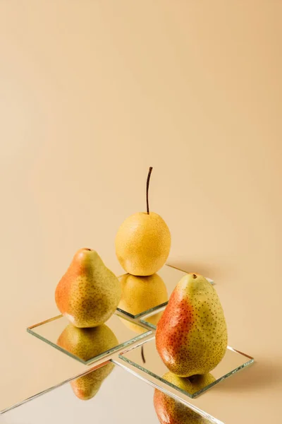 Poires Entières Jaunes Réfléchissant Dans Les Miroirs Sur Table Beige — Photo