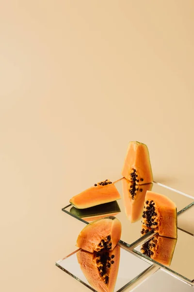 Papaya Pieces Reflecting Mirrors Beige Table — Stock Photo, Image