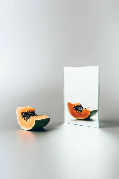 Papaya Exótica Reflejándose Espejo Sobre Mesa Blanca — Foto de stock gratis