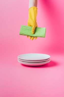 temizlik peçete temiz Beyaz tabaklar, pembe bir arka plan yığını üzerinden tutan kadın resim kırpılmış