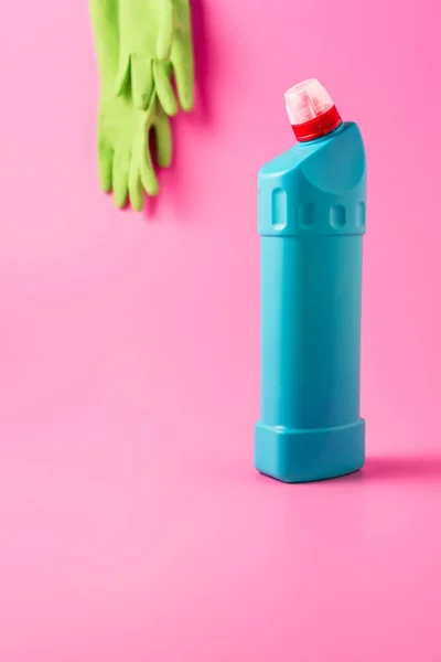 关闭的清洁液和橡胶手套的看法后 粉红色的背景 — 图库照片