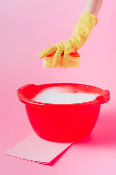 クリーナー泡とプラスチック製洗面器を洗浄スポンジを保持している女性の画像をトリミング ピンクの背景 — ストック写真