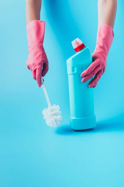 女清洁工持有清洁液和马桶刷 蓝色背景的部分看法 — 图库照片