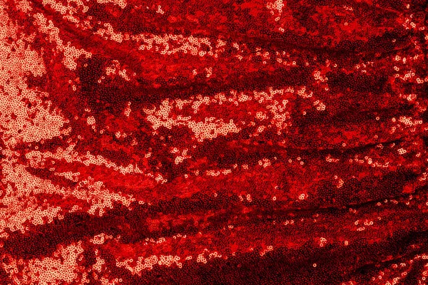 top view of red textile with shiny sequins as background 
