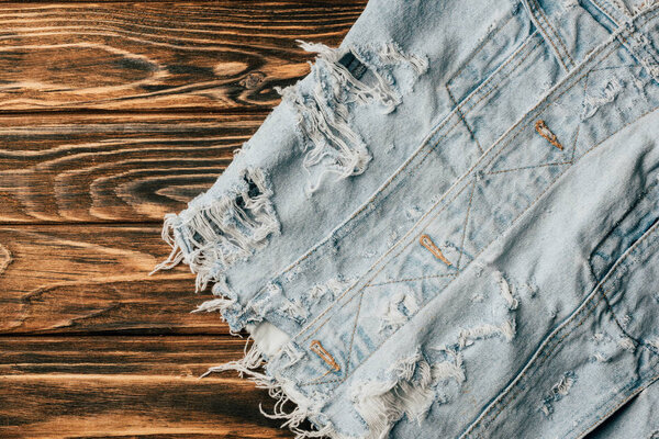 верхний вид светлого джинсового текстиля на деревянный стол
