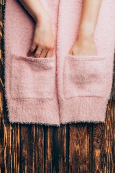 Cropped Image Woman Putting Hands Pockets Pink Sweater Wooden Table — Free Stock Photo
