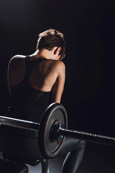 Vista Posteriore Atleta Donna Sportiva Riposo Vicino Bilanciere Sfondo Nero — Foto stock gratuita