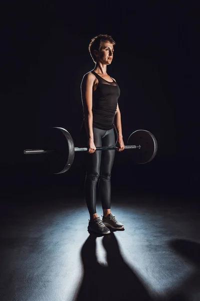 Ernstige Sportvrouw Oefenen Met Barbell Bij Gym Zwarte Achtergrond — Gratis stockfoto