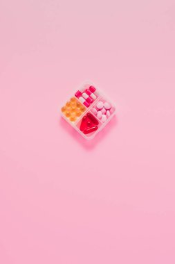 çeşitli sıralanan ilaçlarla birlikte Plastik Konteyner üstten görünüm pembe üzerinde