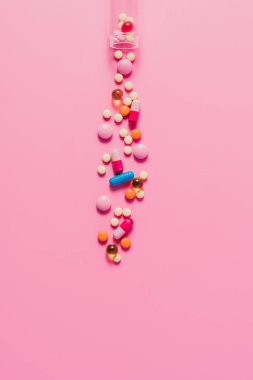 pembe üzerinde çeşitli farklı hapı şişe üstten görünüm