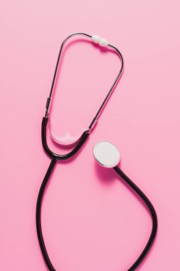 top view of stethoscope lying on pink surface clipart