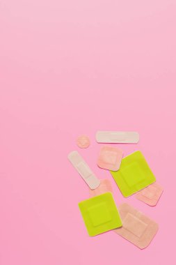 çeşitli yapışkanlı bandaj üstten görünüm pembe masa üzerinde