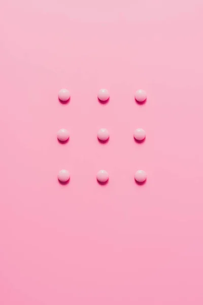 粉红色表面的粉红色药丸的顶部视图 — 图库照片