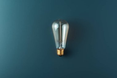 close-up view of single light bulb on grey background clipart