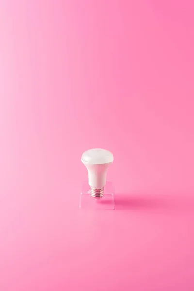 ピンクの背景に単一の電球のクローズ アップ ビュー — ストック写真