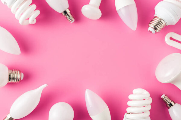 top view of various light bulbs on pink background, energy concept 