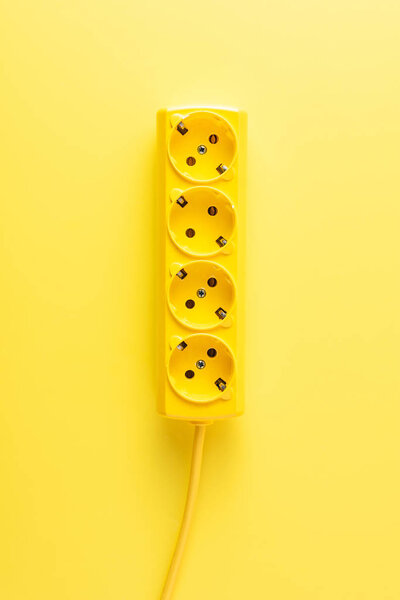 close-up view of bright yellow socket outlet on yellow background